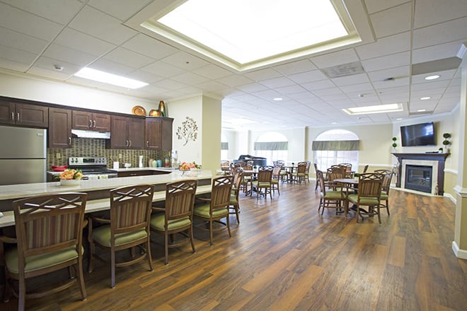 A spacious dining area with wooden flooring and ample seating arrangements.