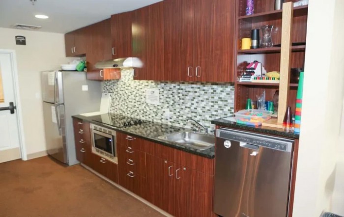 A modern kitchen with sleek wooden cabinets, a tiled backsplash, and stainless steel appliances.
