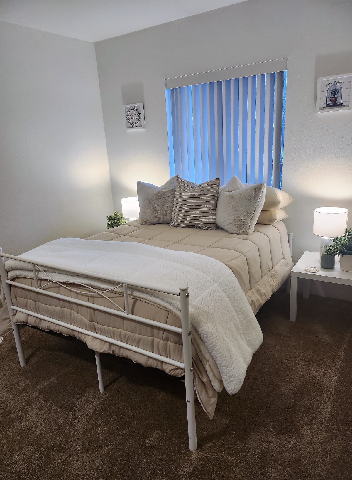A cozy bedroom with a neatly made bed, pillows, and bedside lamps.