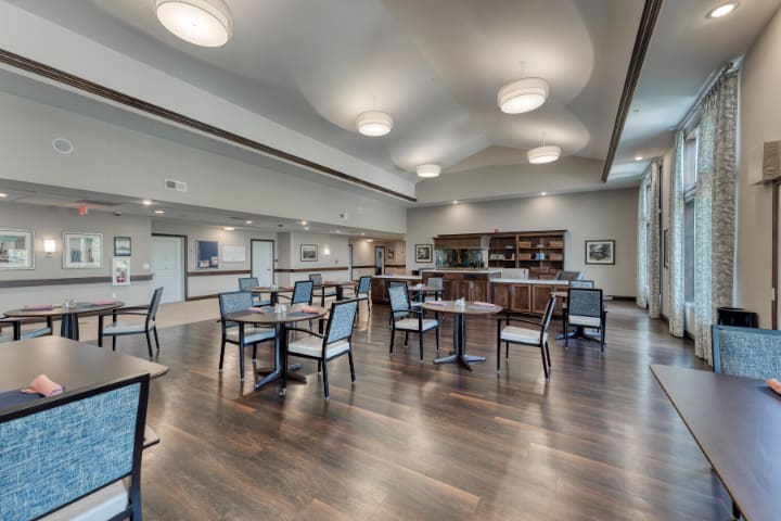 A modern dining area with wooden flooring and contemporary lighting.