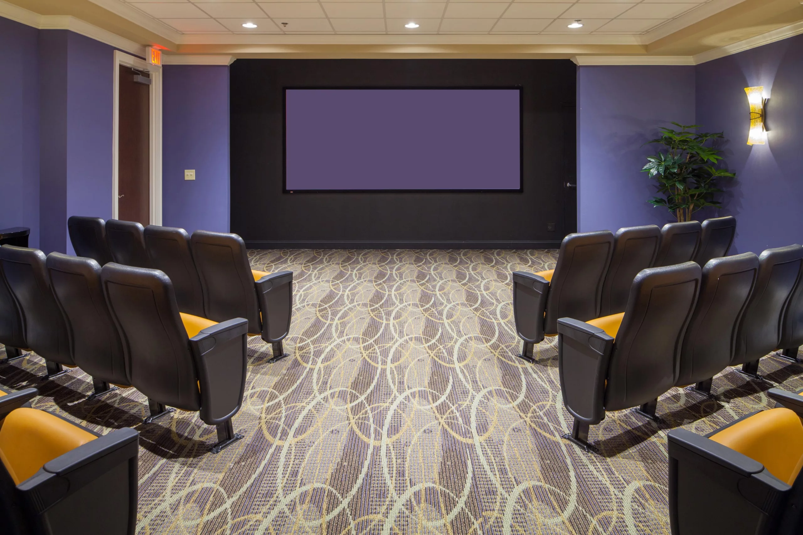 A cozy home theater setup with comfortable seating and a large projector screen.