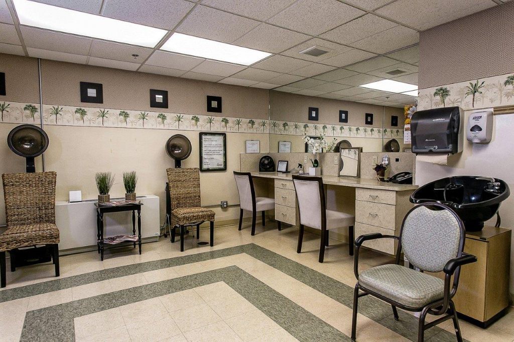 A well-organized salon interior featuring chairs, mirrors, and hair dryers with a cozy waiting area and decorative wall art.