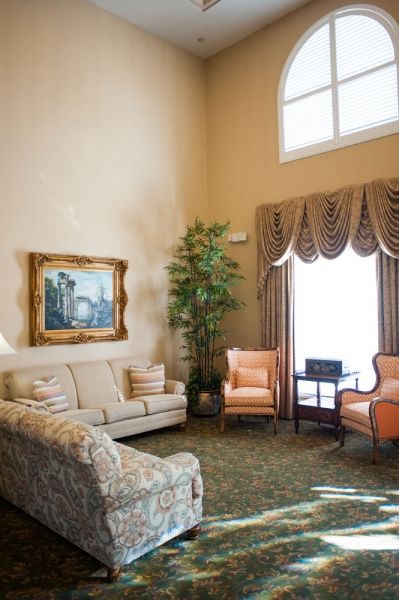 A cozy and elegantly decorated living room with plush furniture and framed artwork.