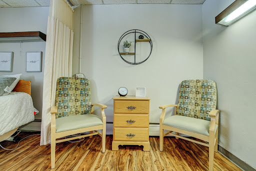 A cozy seating area featuring two patterned chairs and a small wooden table between them.