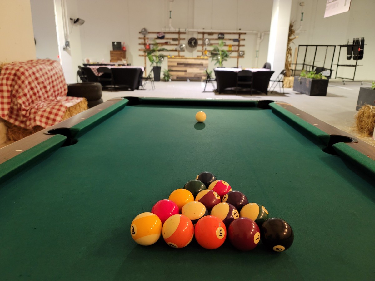 A finely arranged set of pool balls on a billiard table in a cozy game room.
