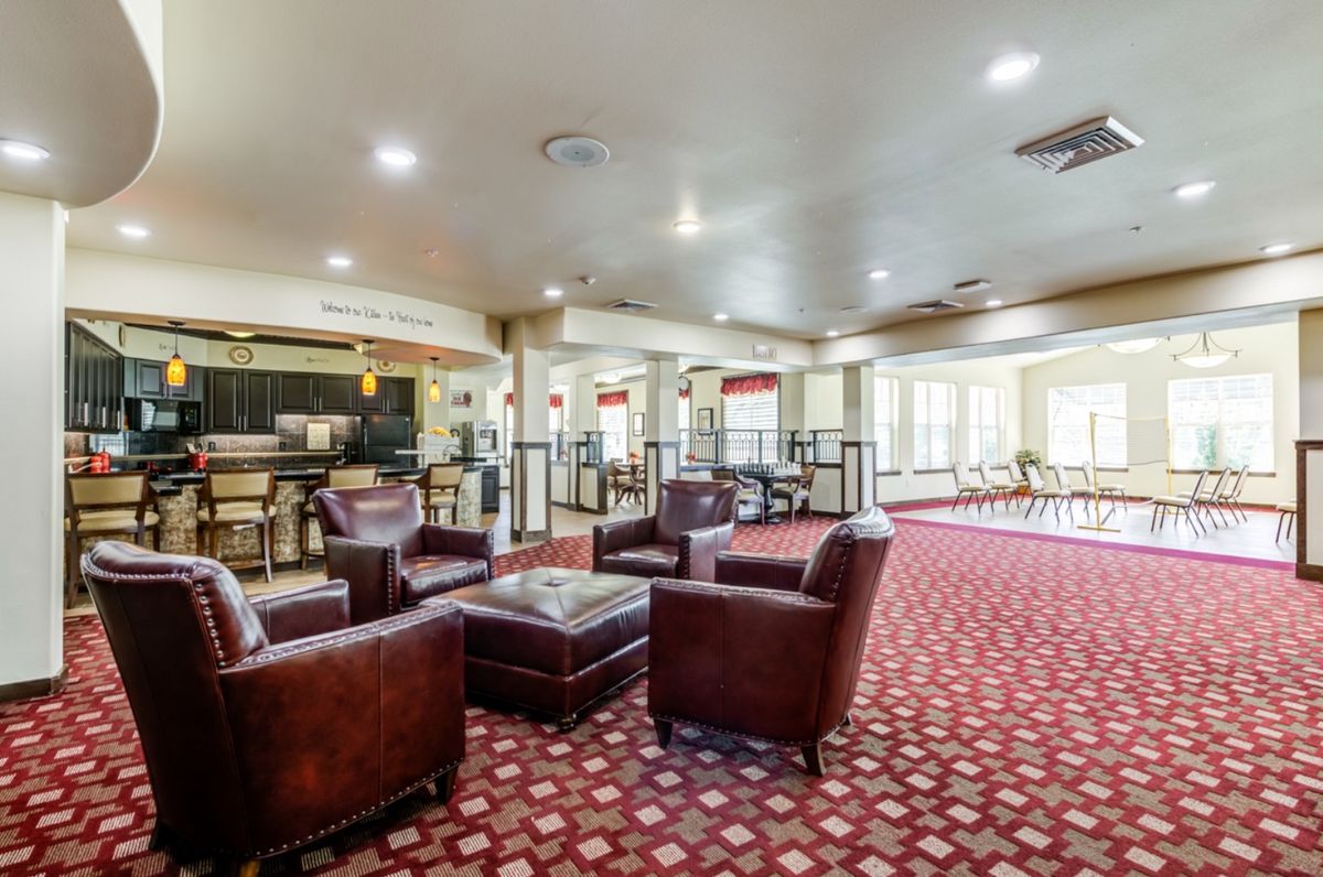 A spacious lobby with comfortable leather seating and a patterned carpet.
