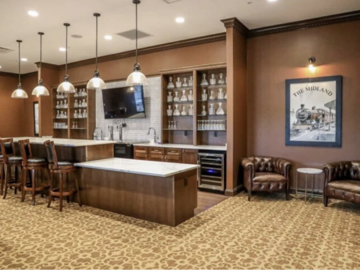 A stylish bar interior with ample shelving and seating.