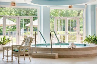A serene indoor jacuzzi area with ample natural light and comfortable seating.