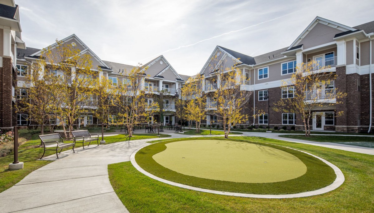 A view of a modern residential apartment complex with landscaped surroundings and green spaces.