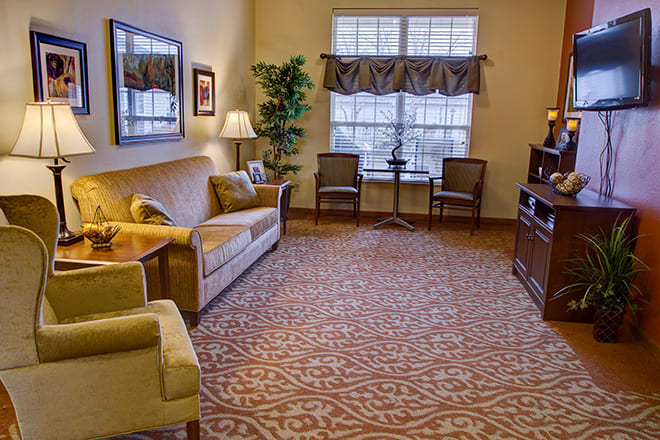 A cozy living room with a sofa, armchairs, and a carpeted floor.