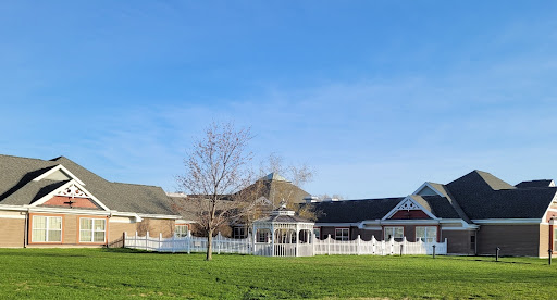 A picturesque view of a residential building with a white fence under a clear blue sky.