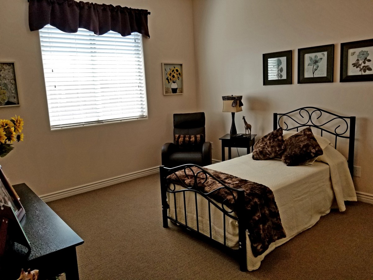A cozy bedroom with a single bed, decorated with warm colors and artistic elements.