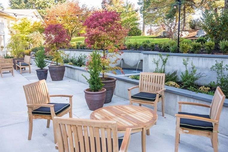 Outdoor patio area with wooden furniture and potted plants.