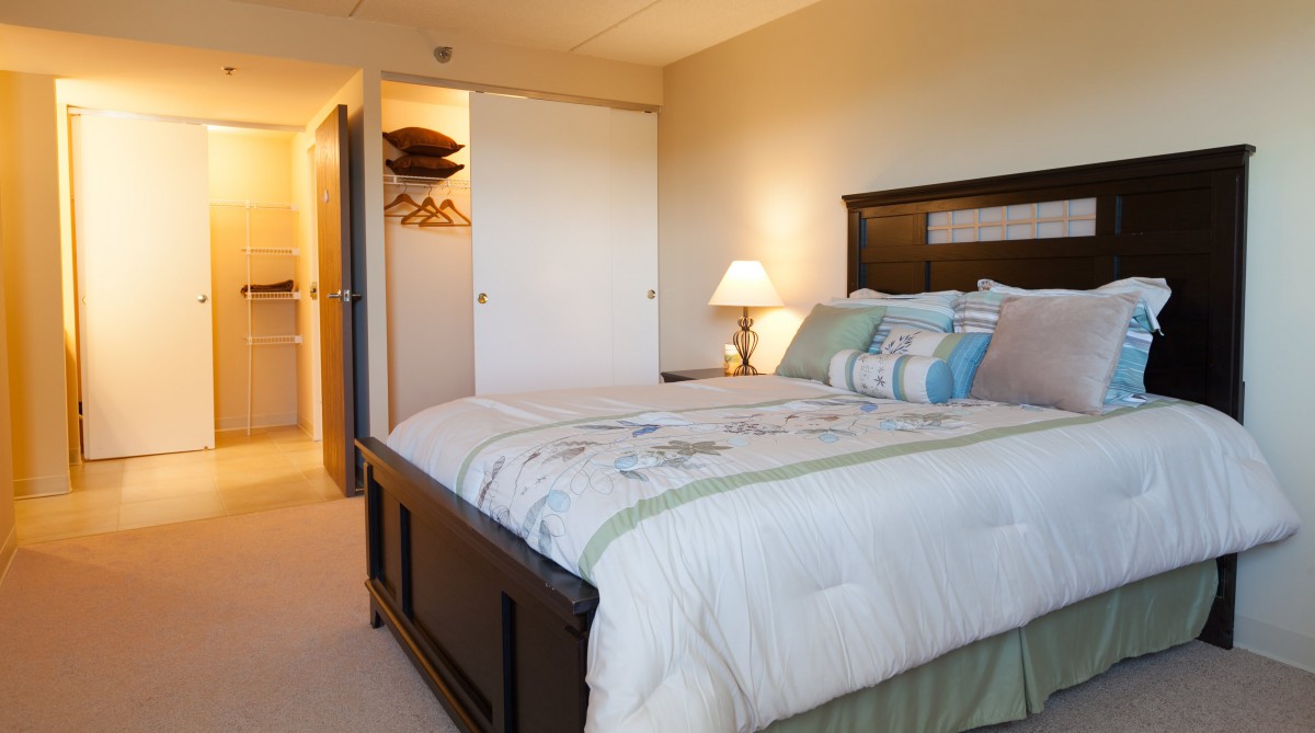 A cozy bedroom with a comfortable bed and a small lamp lighting the room.
