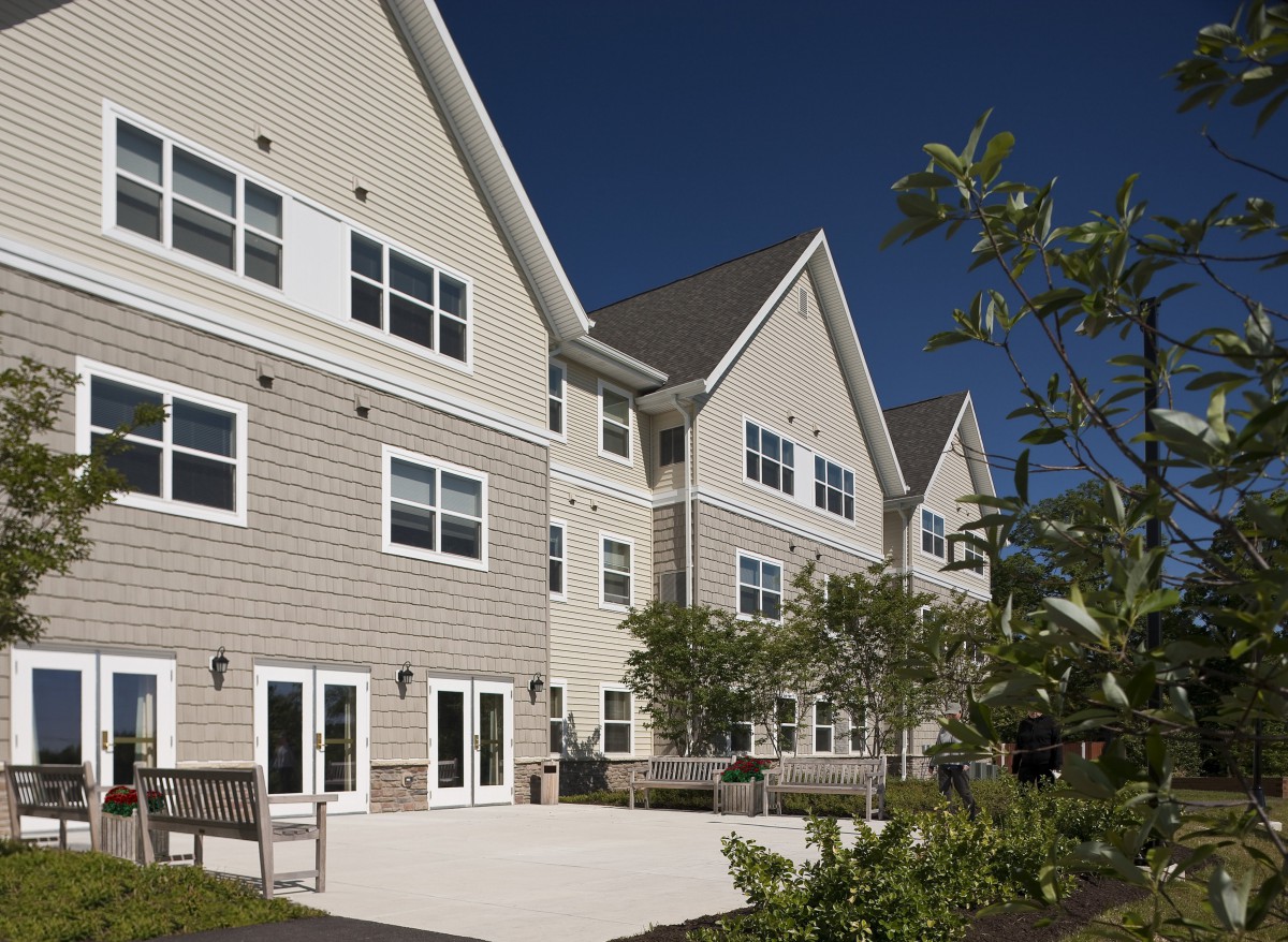 Exterior view of a residential building with trees in the foreground.