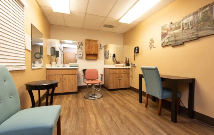 A cozy salon interior with mirrors, chairs, and warm lighting.