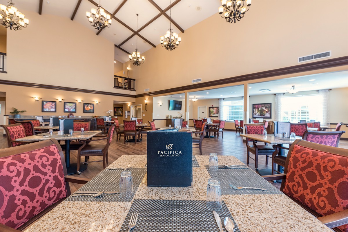 A spacious and elegantly decorated restaurant dining area with neatly arranged tables.