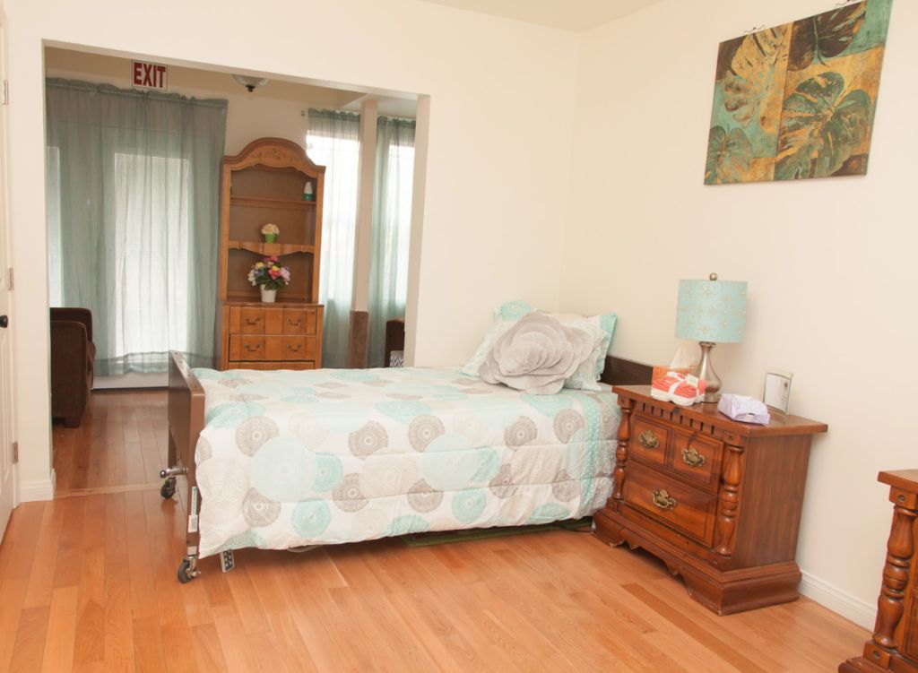 A cozy bedroom with a single bed, nightstand, and wooden furniture.