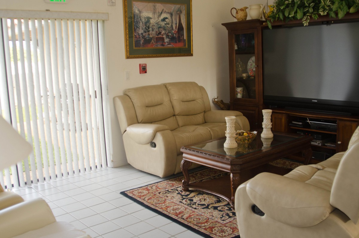 A cozy living room with a beige sofa, wooden coffee table, and a large television.