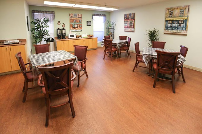 A spacious dining area with multiple tables and chairs, adorned with plants and wall decorations.