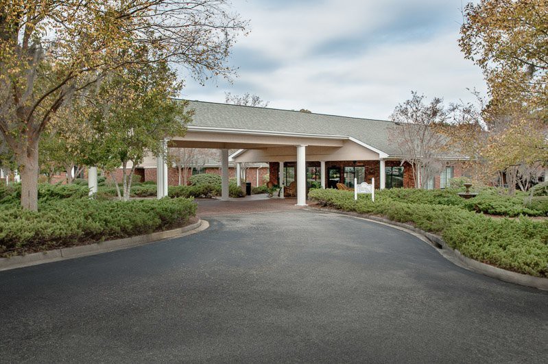 A building entrance with a circular driveway surrounded by greenery.