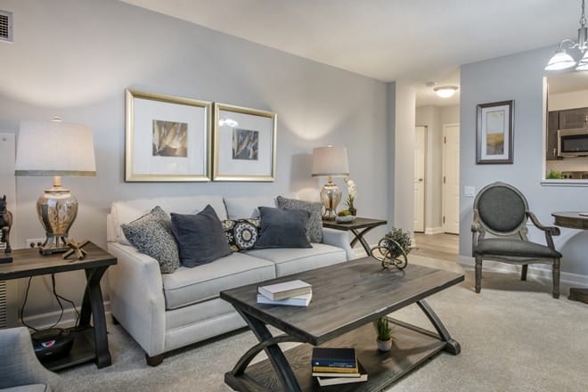 A cozy living room featuring a comfortable sofa with cushions, a stylish coffee table, and elegant artwork.