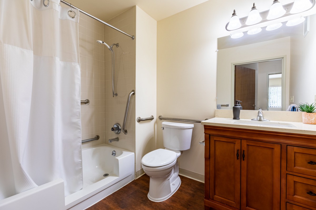 A clean and modern bathroom with a shower, toilet, and vanity.