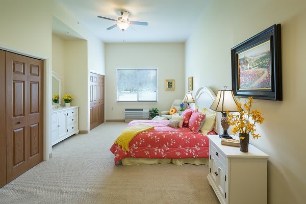 A cozy and brightly decorated bedroom with a vibrant bedspread and elegant furnishings.