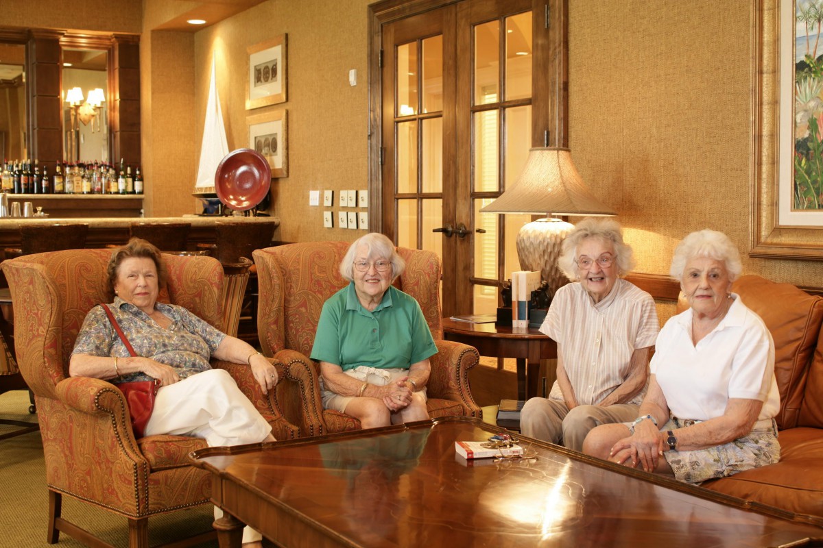 A group of elderly women sitting together in a living room.