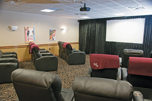 A cozy home theater setup featuring recliner chairs and a projection screen, perfect for movie nights.