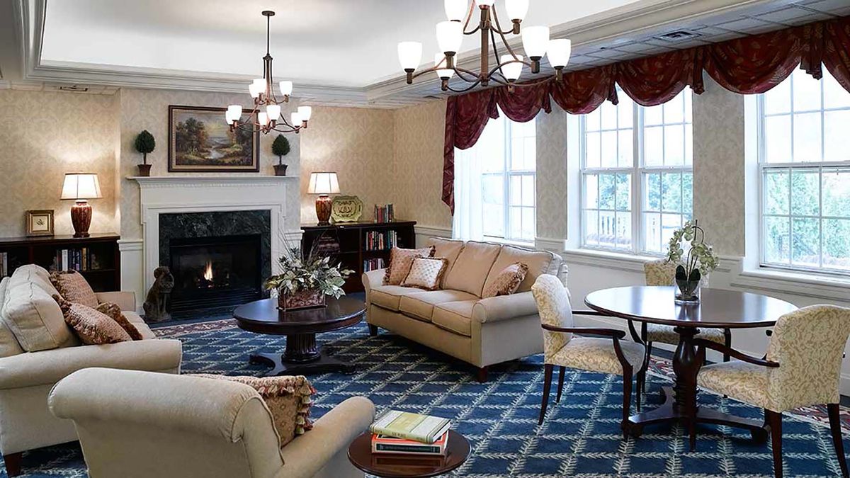 A cozy living room with elegant furnishings, including a sofa, coffee table, and fireplace.