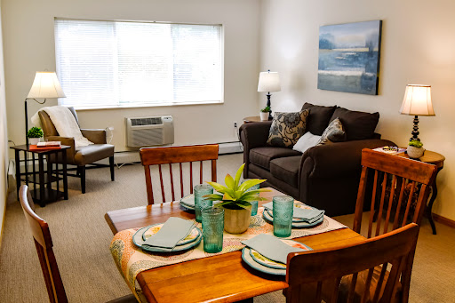 A cozy living room and dining area, featuring a well-set table and inviting seating.