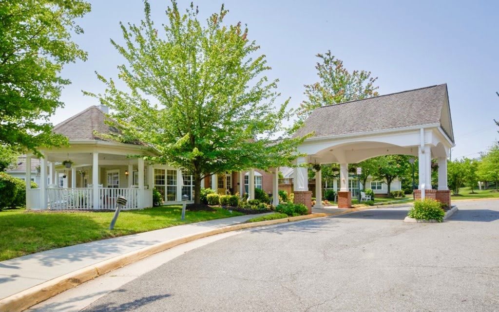 A welcoming building with a covered entrance surrounded by greenery.