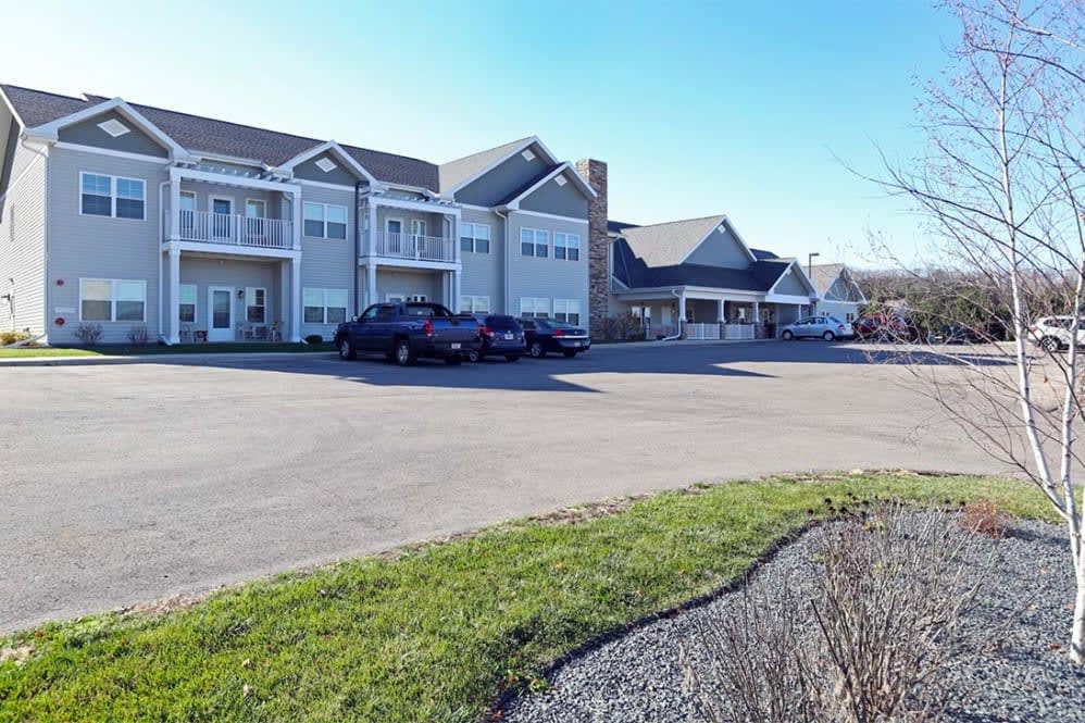 A residential building with a parking lot and cars on a clear day.