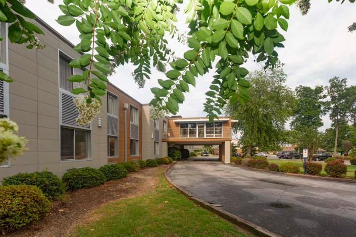 A modern building with a sky bridge surrounded by lush greenery.