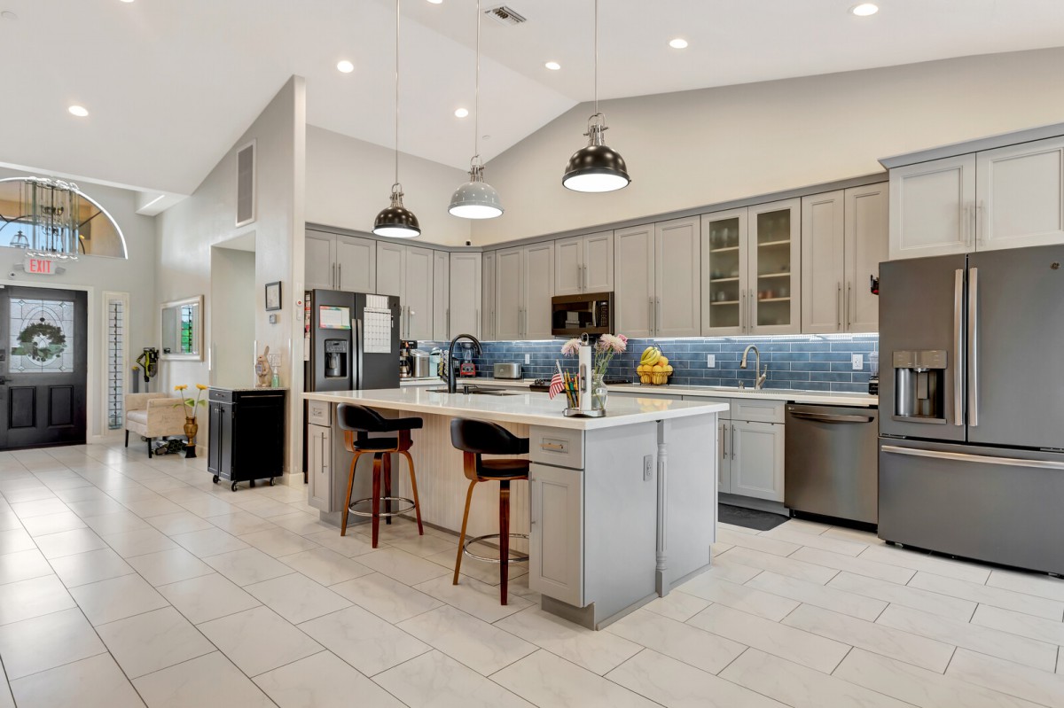 A modern kitchen with a central island, sleek appliances, and stylish pendant lighting.