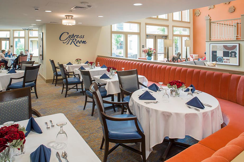 An elegant restaurant dining room with neatly set tables and comfortable chairs.
