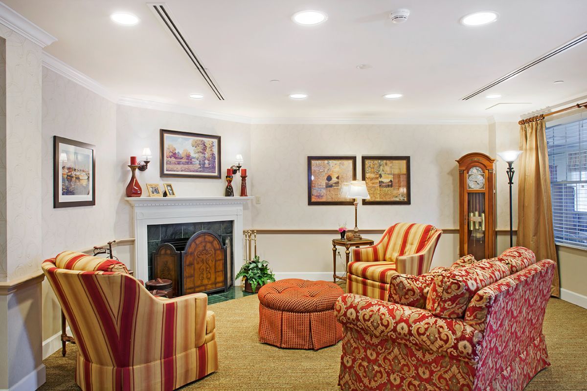 A cozy living room with a traditional design, featuring comfortable armchairs and a fireplace.
