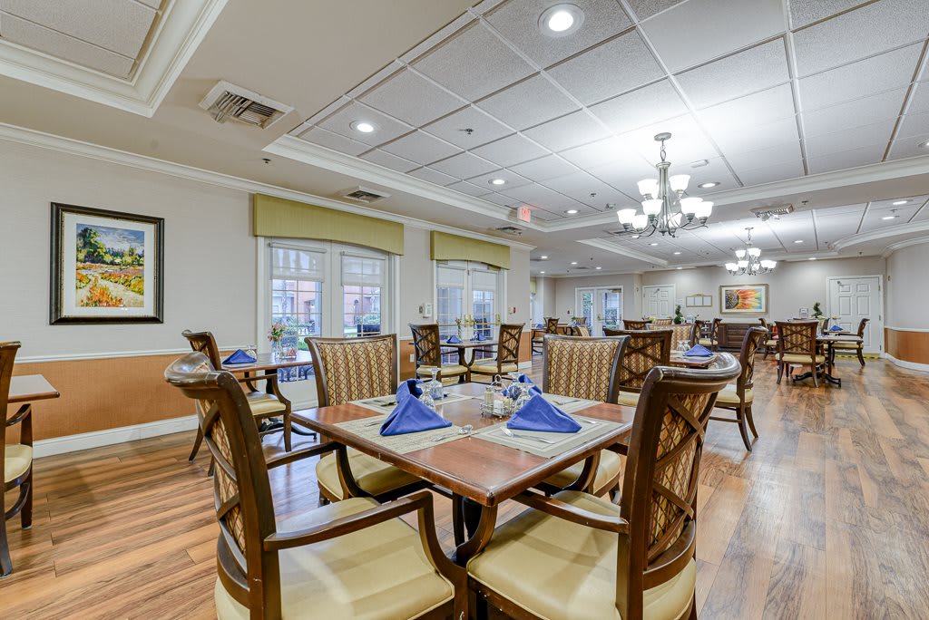 A cozy and well-lit dining area with neatly arranged tables and chairs, ready for guests.