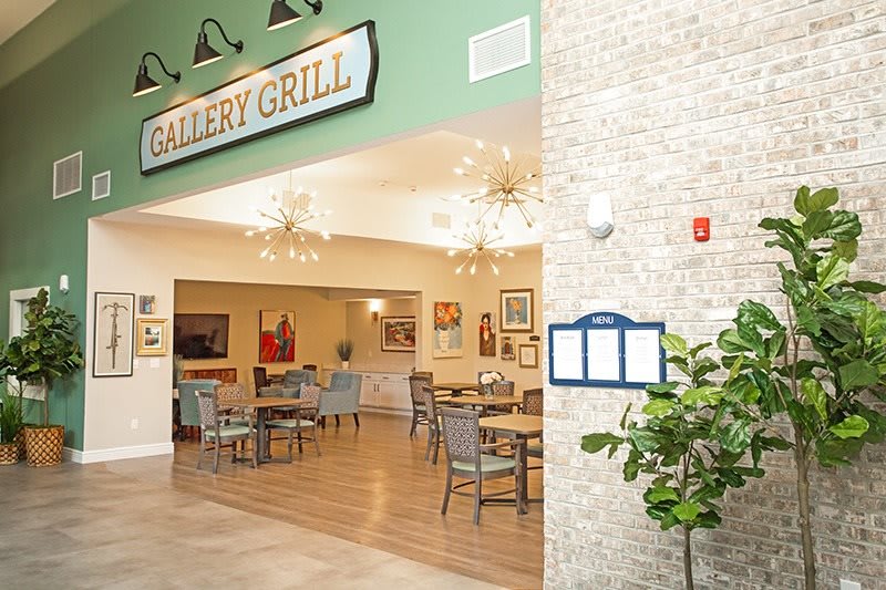 An indoor view of a restaurant's dining area featuring tables, chairs, and decorative lighting.