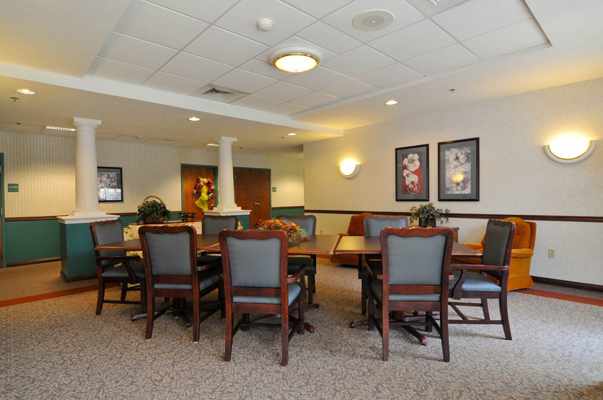 A cozy dining area with tables and chairs, decorated with wall art and ambient lighting.