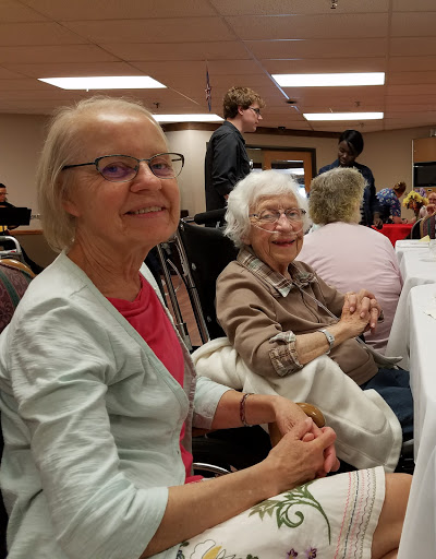 Two cheerful women enjoying a social gathering.