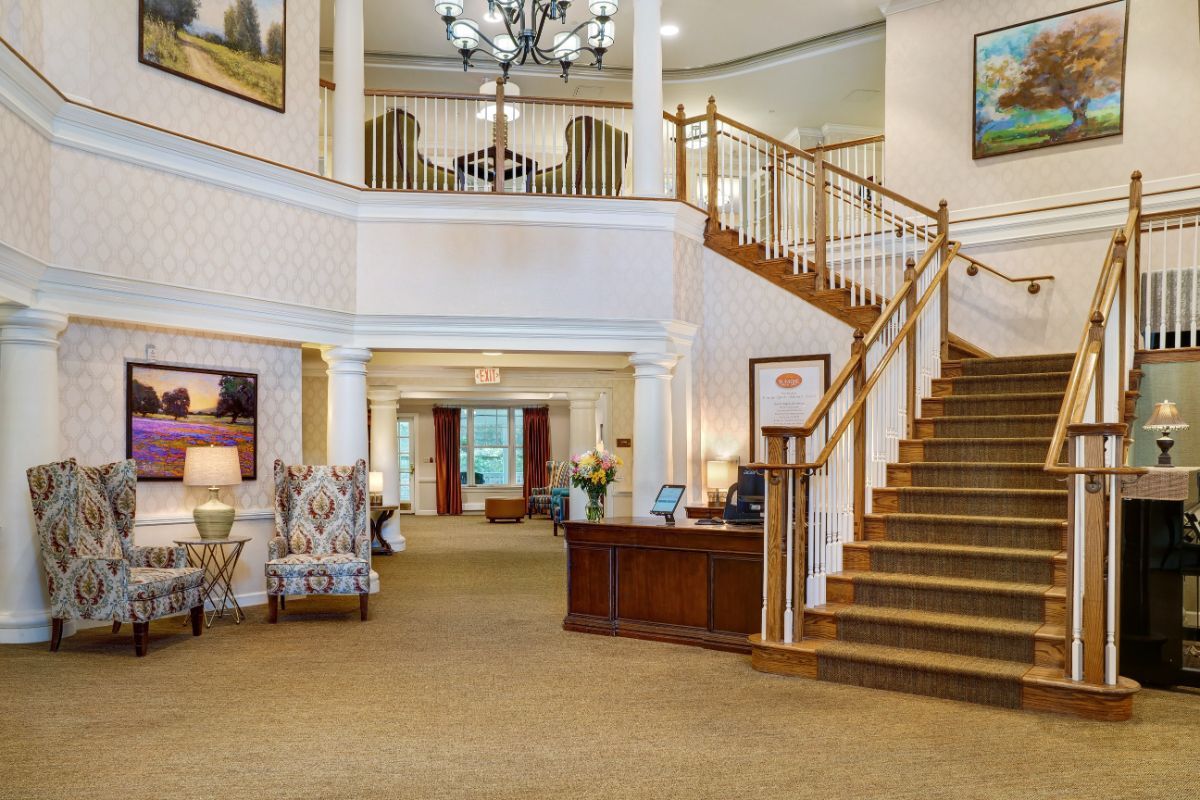 A spacious and elegantly designed lobby with a grand staircase and reception area.