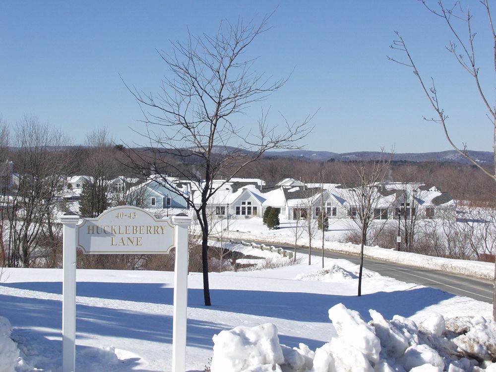 A snowy neighborhood under a clear blue sky.