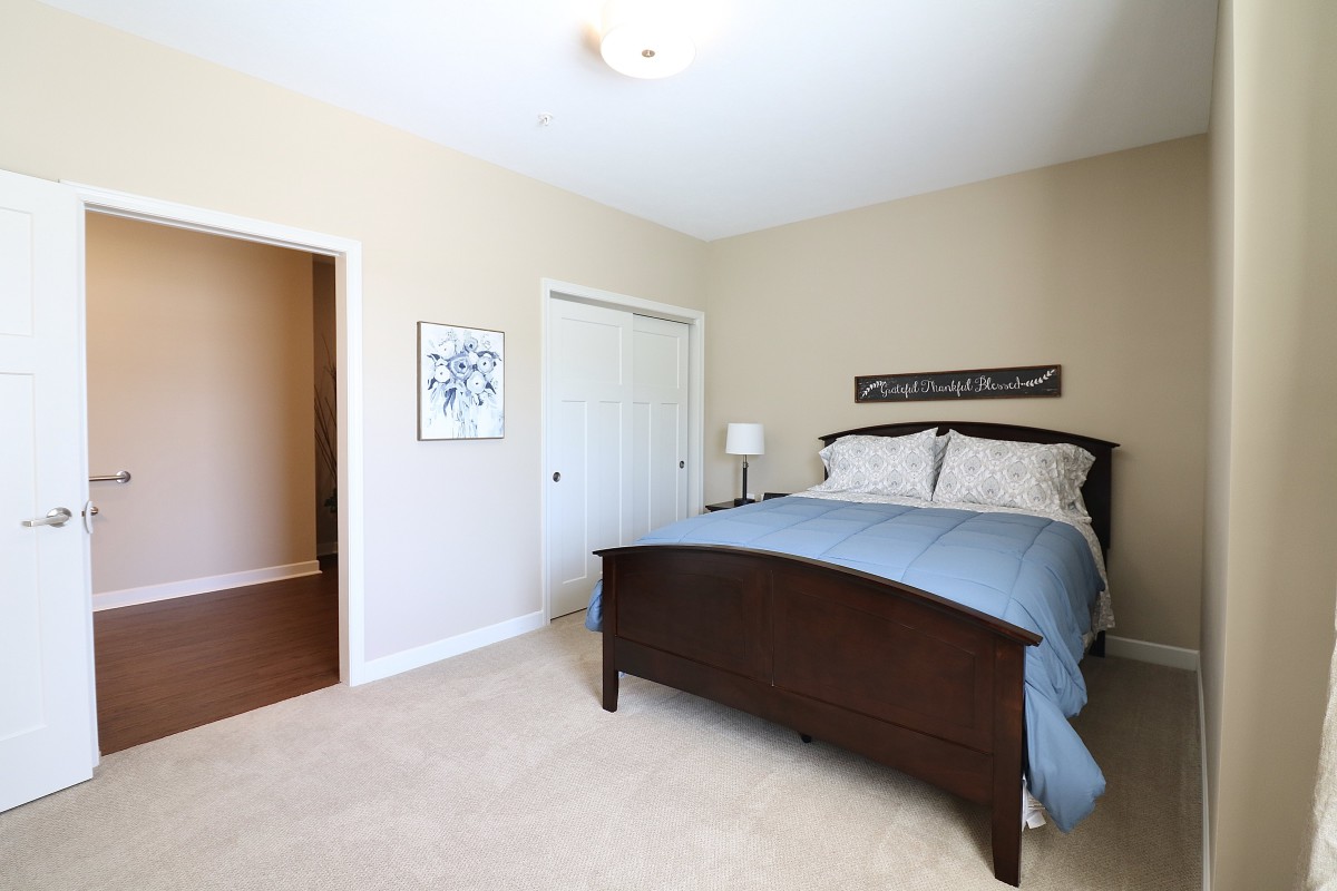 A cozy bedroom with a large bed, soft lighting, and minimalistic decor.