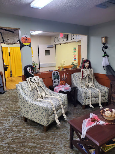 A playful Halloween decoration featuring skeletons sitting in chairs, adding a spooky touch to the living room.