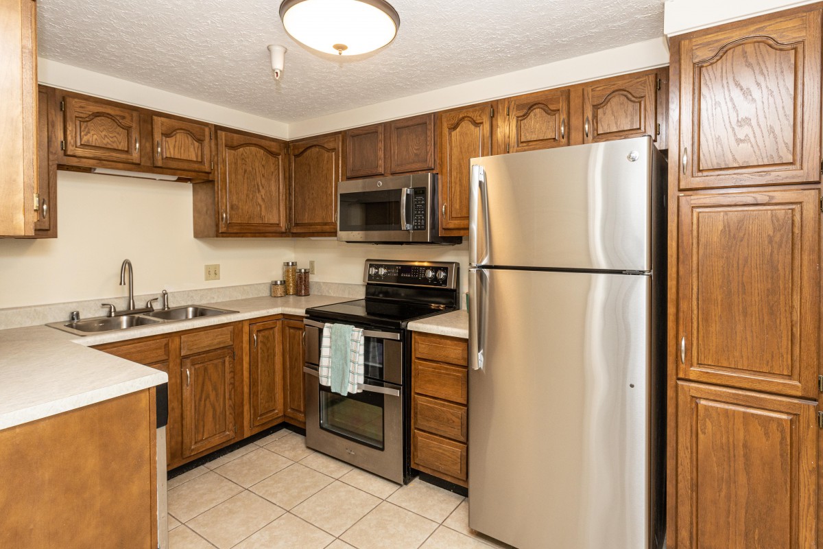A modern kitchen with stainless steel appliances and wood cabinetry.