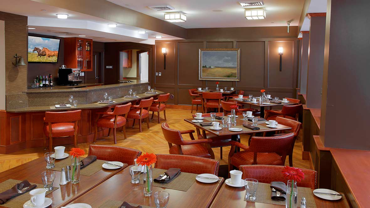 A modern restaurant dining area with neatly arranged tables and warm lighting.