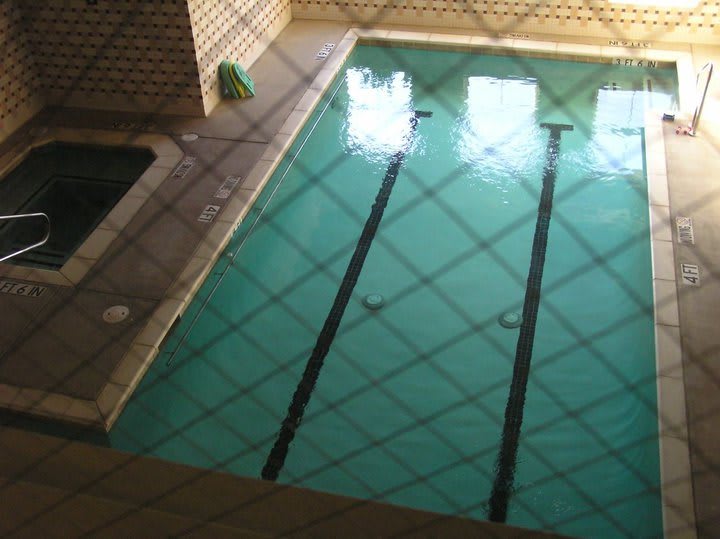 An indoor swimming pool with lane markings and tiled surroundings.