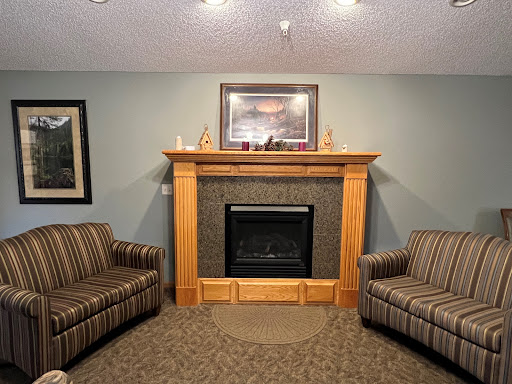 A cozy living room featuring a fireplace and comfortable striped sofas.